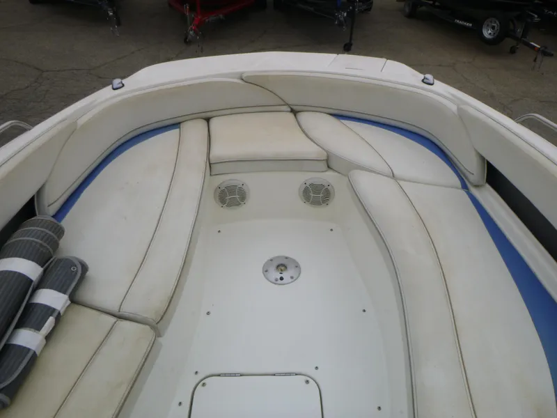 Slide: The Image of 2007 Bayliner 197 Deck Boat interior seating area with white cushions and storage compartments. - 9