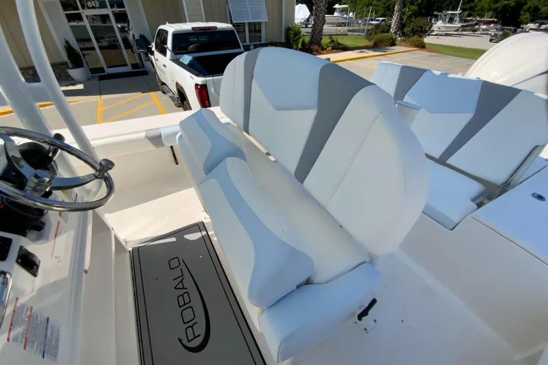 Slide: The Image of 2024 Robalo 246 Cayman boat interior with cushioned seating and steering wheel. - 13