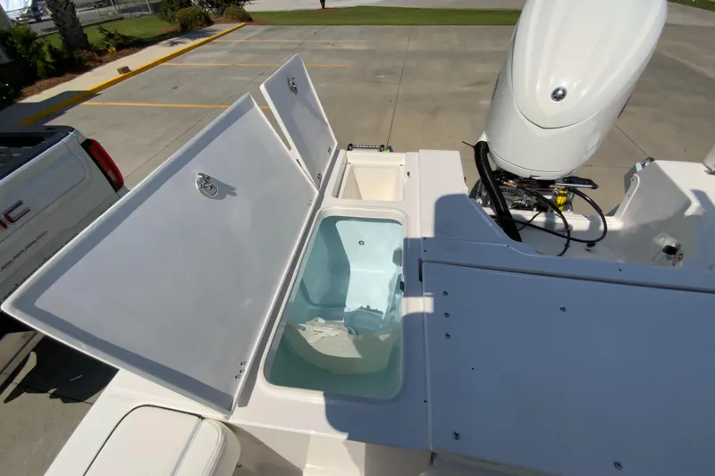 Slide: The Image of 2024 Robalo 246 Cayman boat with open storage compartments and outboard motor. - 9