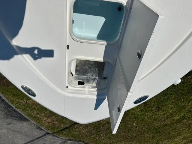 Slide: The Image of 2024 Robalo 246 Cayman boat storage compartments open on deck. - 11