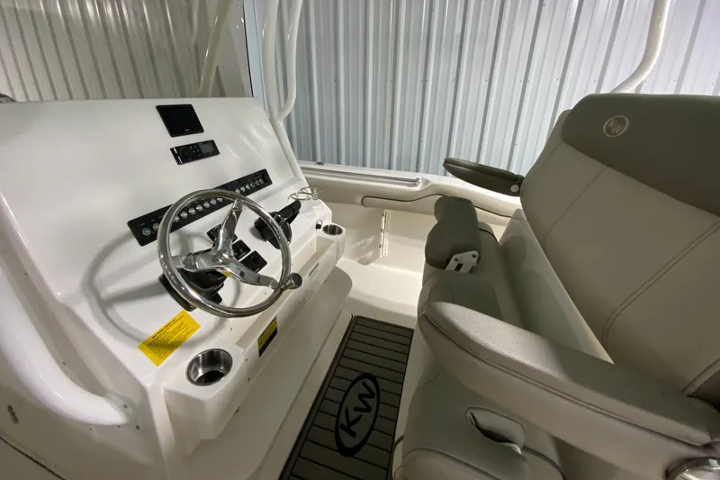 Slide: The Image of 2024 Key West 263 FS boat interior with steering wheel and seating. - 12