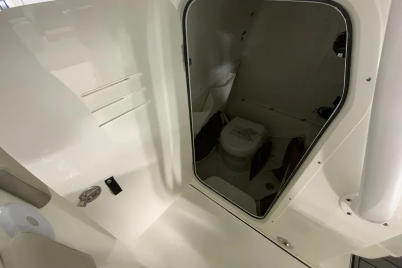 Slide: The Image of 2024 Key West 263 FS boat interior with a compact marine toilet. - 21