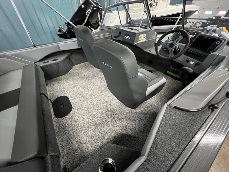Slide: The Image of 2023 MirroCraft 176 Dual Impact boat interior with gray seating and modern dashboard. - 5