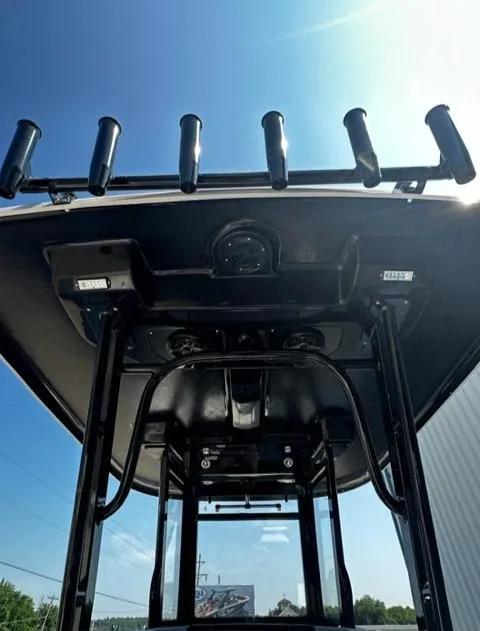 Slide: The Image of 2023 Robalo R270 boat with rod holders and T-top under blue sky. - 4