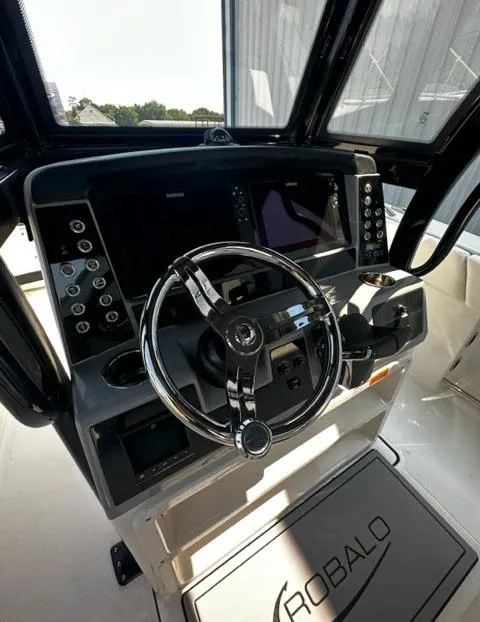 Slide: The Image of 2023 Robalo R270 boat dashboard with modern controls and steering wheel. - 9