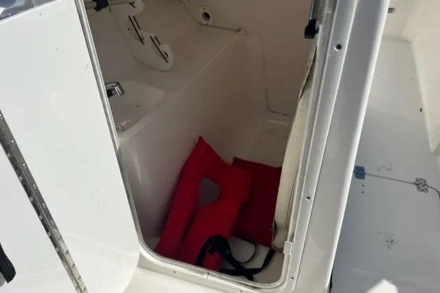 Slide: The Image of 2018 Key West 239 DFS boat storage compartment with red life jackets. - 11