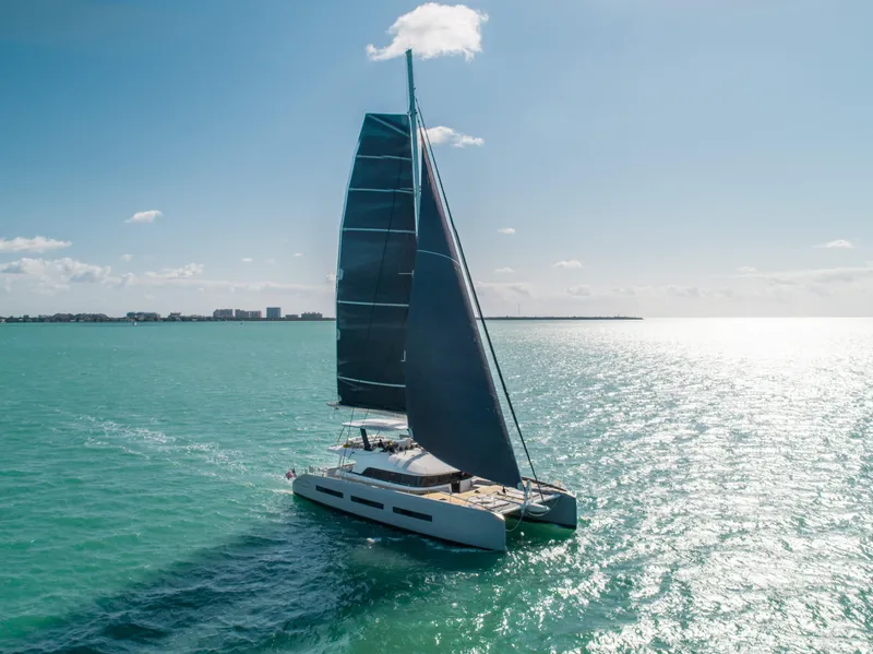 Slide: The Image of 2020 Lagoon SEVENTY 7 sailing on turquoise ocean under clear sky. - 0