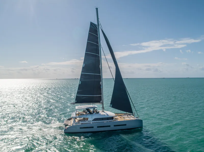 Slide: The Image of 2020 Lagoon SEVENTY 7 catamaran sailing on open sea under clear blue sky. - 1