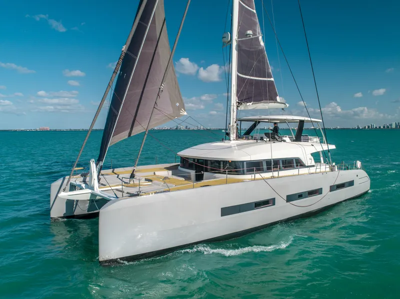 Slide: The Image of 2020 Lagoon SEVENTY 7 catamaran sailing on turquoise waters under clear skies. - 12