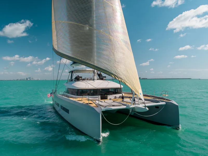 Slide: The Image of 2020 Lagoon SEVENTY 7 catamaran sailing on turquoise waters under a clear blue sky. - 27