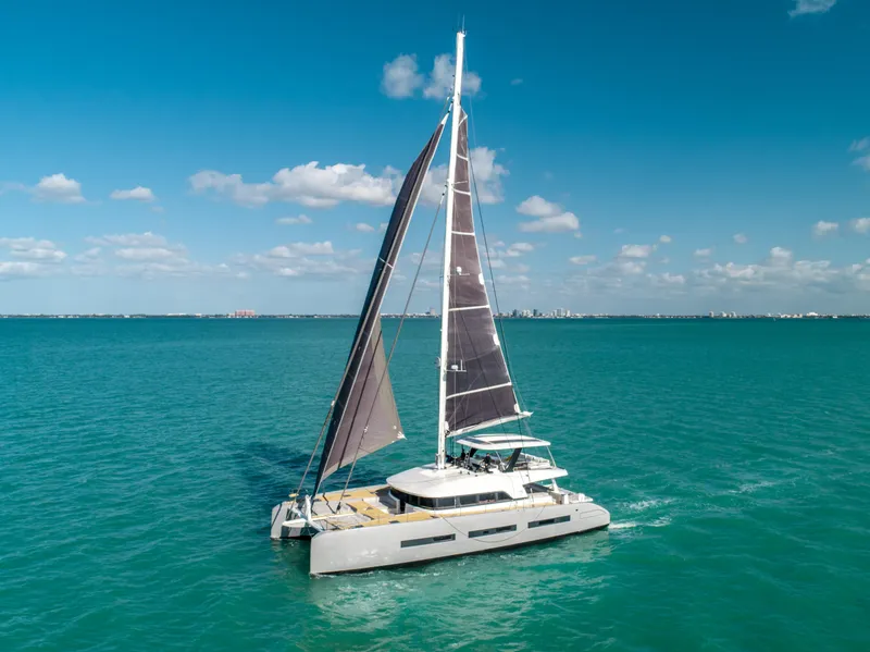 Slide: The Image of 2020 Lagoon SEVENTY 7 catamaran sailing on turquoise ocean under clear blue sky. - 4