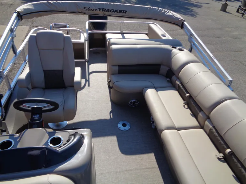 Slide: The Image of 2023 Sun Tracker Sportfish 24 XP3 pontoon boat interior with beige seating and steering console. - 11