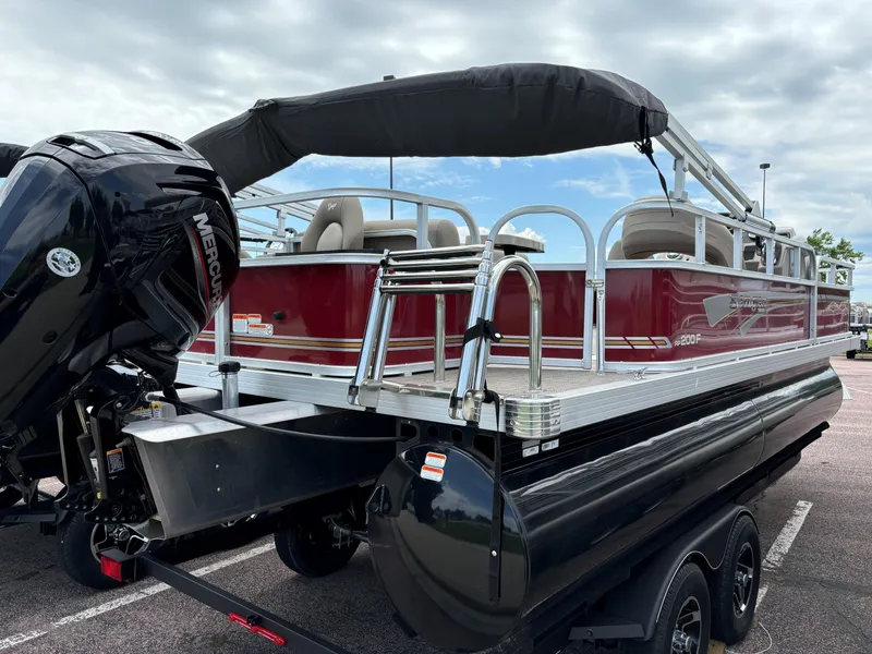 Slide: The Image of 2023 Ranger Reata 200F pontoon boat with Mercury engine, parked on trailer. - 4