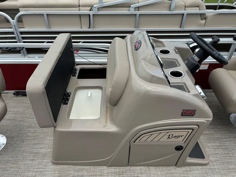 Slide: The Image of 2023 Ranger Reata 200F boat console with beige seating and storage compartment. - 9