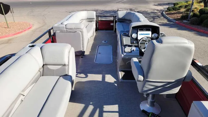 Slide: The Image of 2023 Regency 250 DL3 pontoon boat interior with plush seating and modern dashboard. - 11