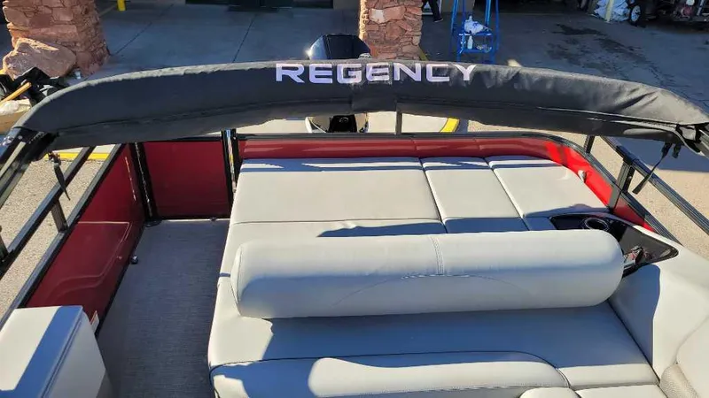 Slide: The Image of 2023 Regency 250 DL3 pontoon boat with cushioned seating and canopy. - 12