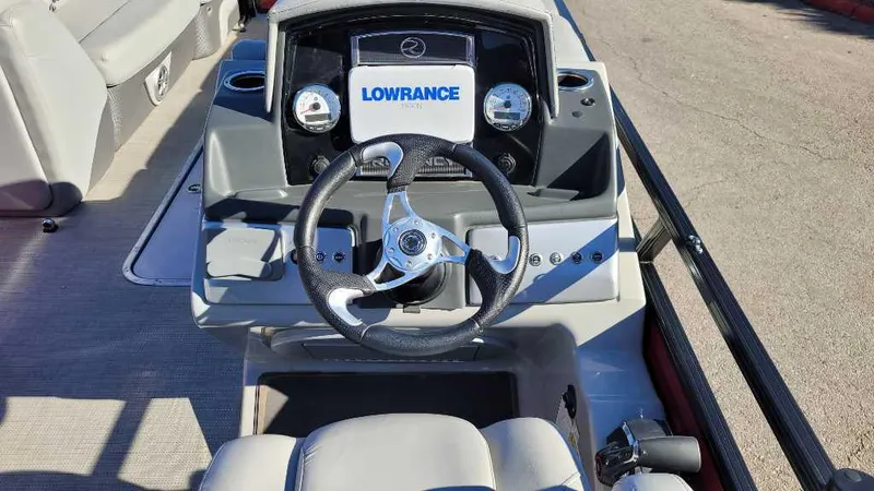 Slide: The Image of 2023 Regency 250 DL3 boat dashboard with Lowrance navigation system and steering wheel. - 7