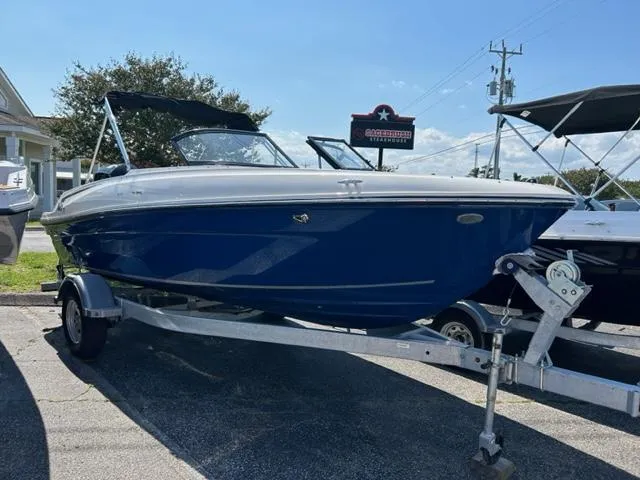 Slide: The Image of 2024 Bayliner VR4 boat on a trailer in a parking lot. - 0