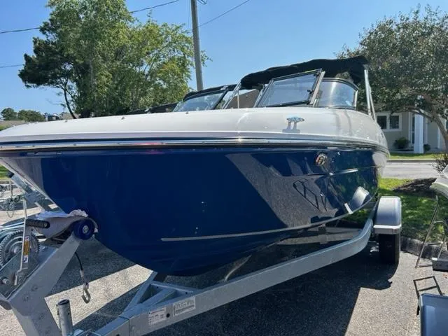 Slide: The Image of 2024 Bayliner VR4 boat on a trailer in a residential area. - 1