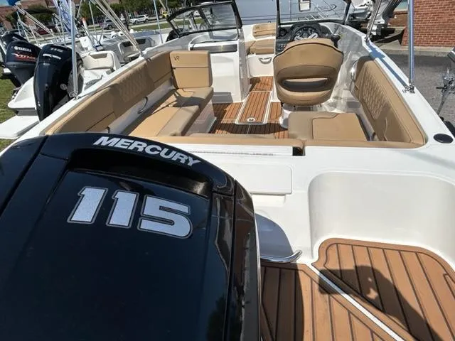 Slide: The Image of 2024 Bayliner VR4 boat interior with Mercury 115 engine, tan seating, and wood flooring. - 4
