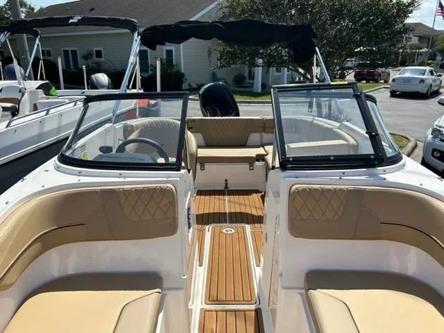 Slide: The Image of 2024 Bayliner VR4 boat interior with tan seating and wood flooring. - 8