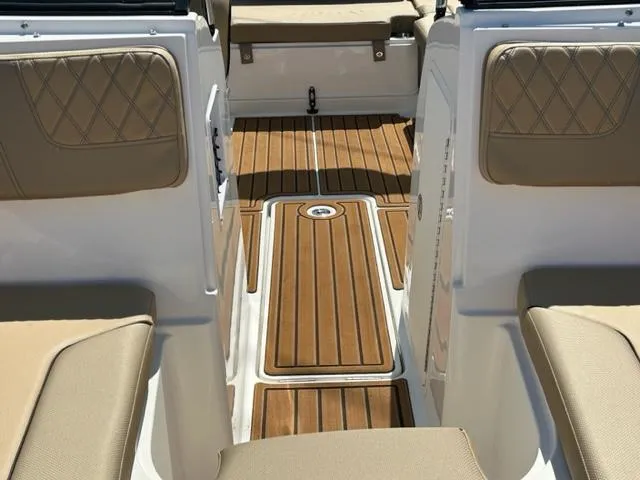 Slide: The Image of 2024 Bayliner VR4 boat interior with tan seats and wooden flooring. - 9