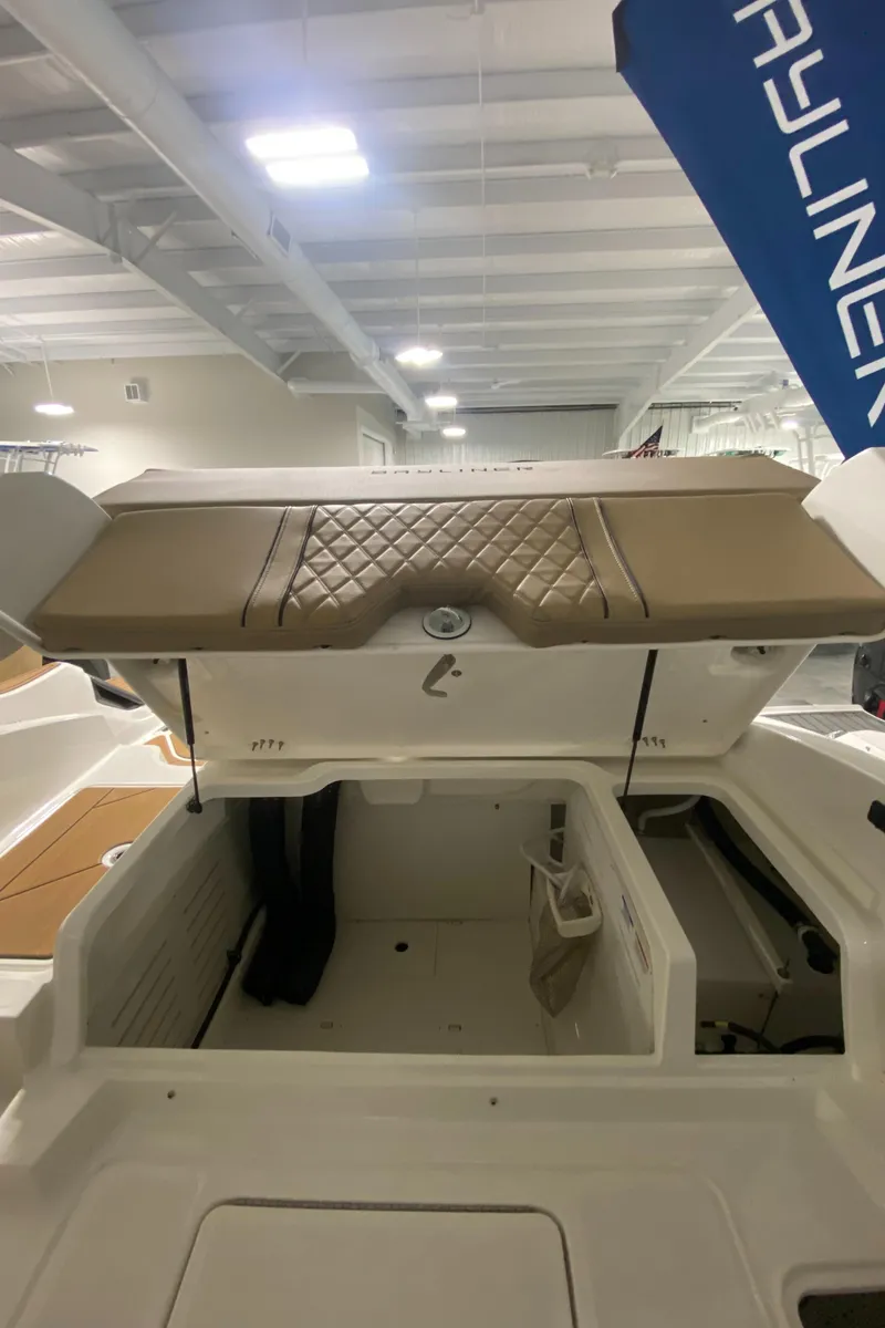 Slide: The Image of 2024 Bayliner DX2000 boat storage compartment with cushioned seating. - 13