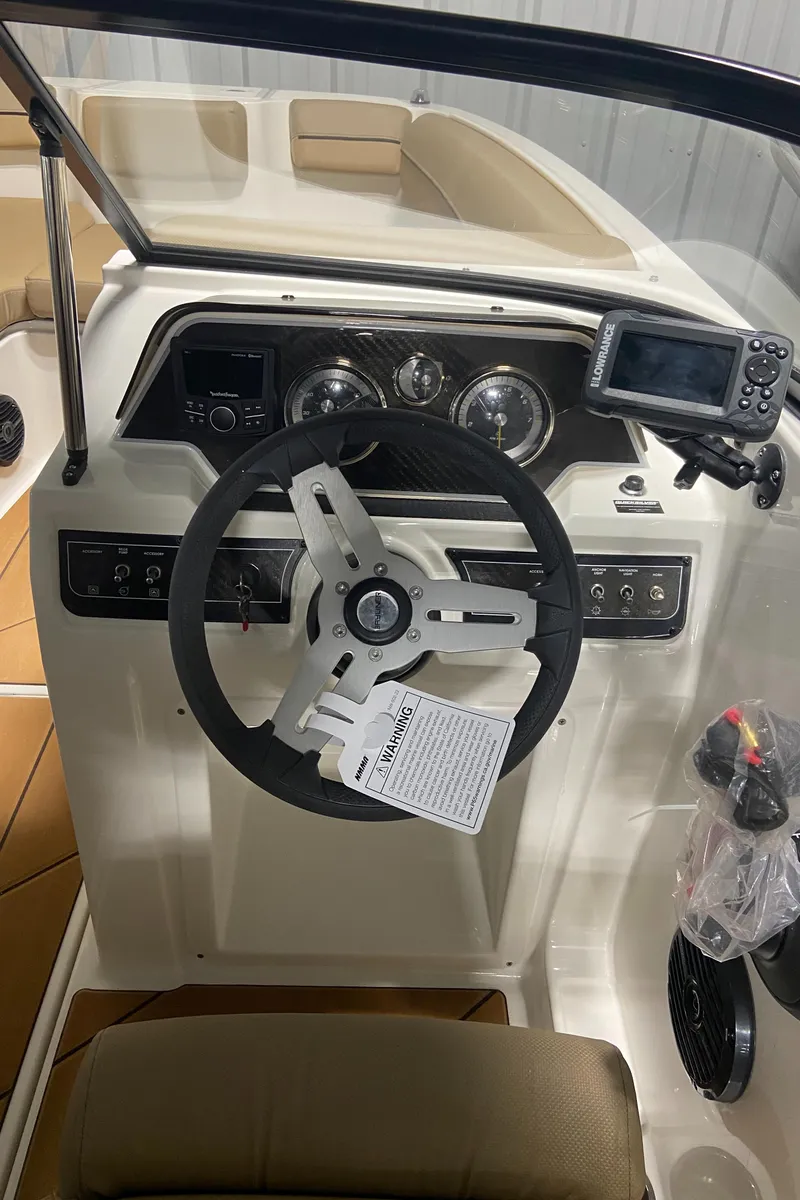 Slide: The Image of 2024 Bayliner DX2000 boat dashboard with steering wheel and navigation system. - 16