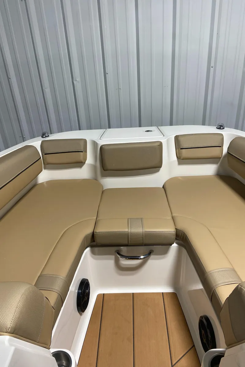 Slide: The Image of 2024 Bayliner DX2000 boat interior with tan seating and wood flooring. - 18