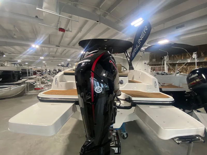Slide: The Image of 2024 Bayliner DX2000 boat with outboard motor in showroom. - 2