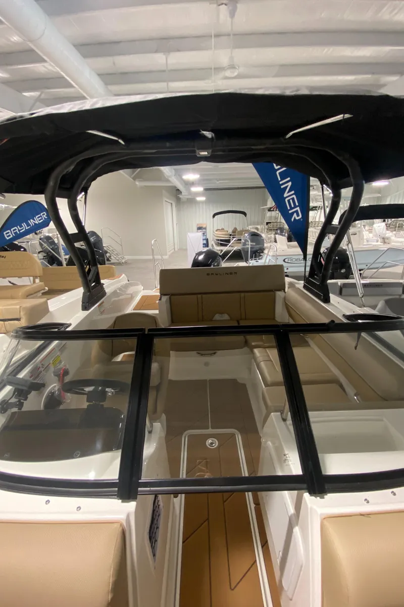 Slide: The Image of 2024 Bayliner DX2000 boat interior with black canopy and beige seating. - 21