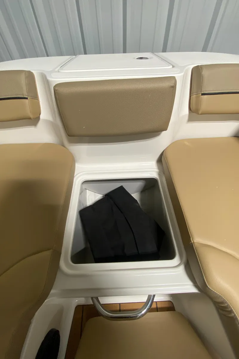 Slide: The Image of 2024 Bayliner DX2000 boat interior storage compartment with tan seating. - 22