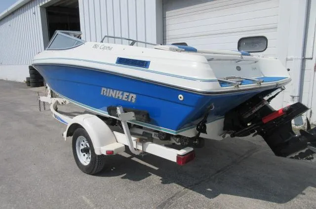 Slide: The Image of 1993 Rinker 186 Captiva boat on trailer, blue and white, parked outside a warehouse. - 4