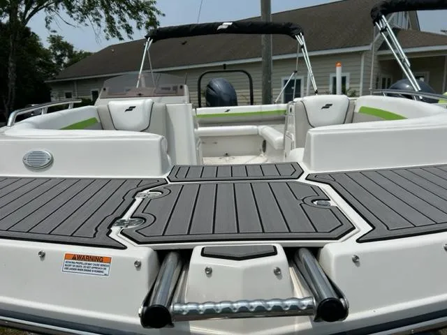 Slide: The Image of 2024 Starcraft SVX 211 Lime Green Sport boat, rear deck view with seating and swim platform. - 6