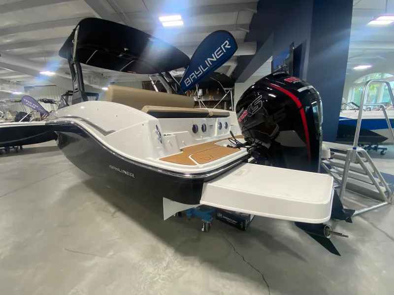 Slide: The Image of 2024 Bayliner DX2000 boat on display in a showroom. - 2