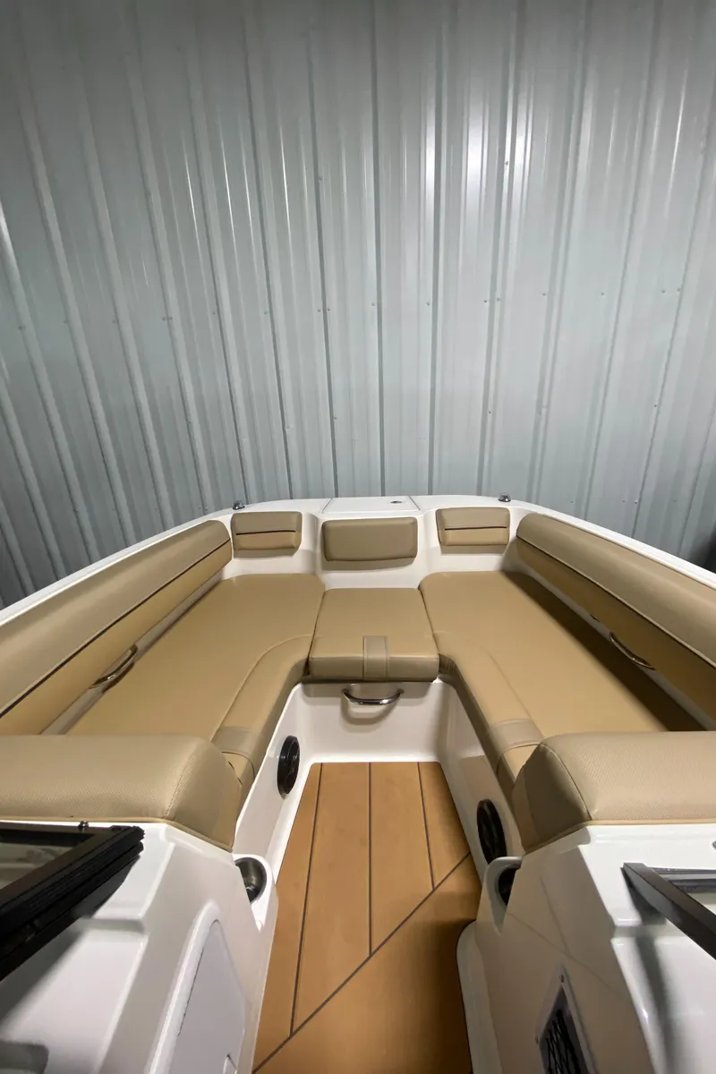 Slide: The Image of 2024 Bayliner DX2000 boat interior with tan seating and wood flooring. - 20