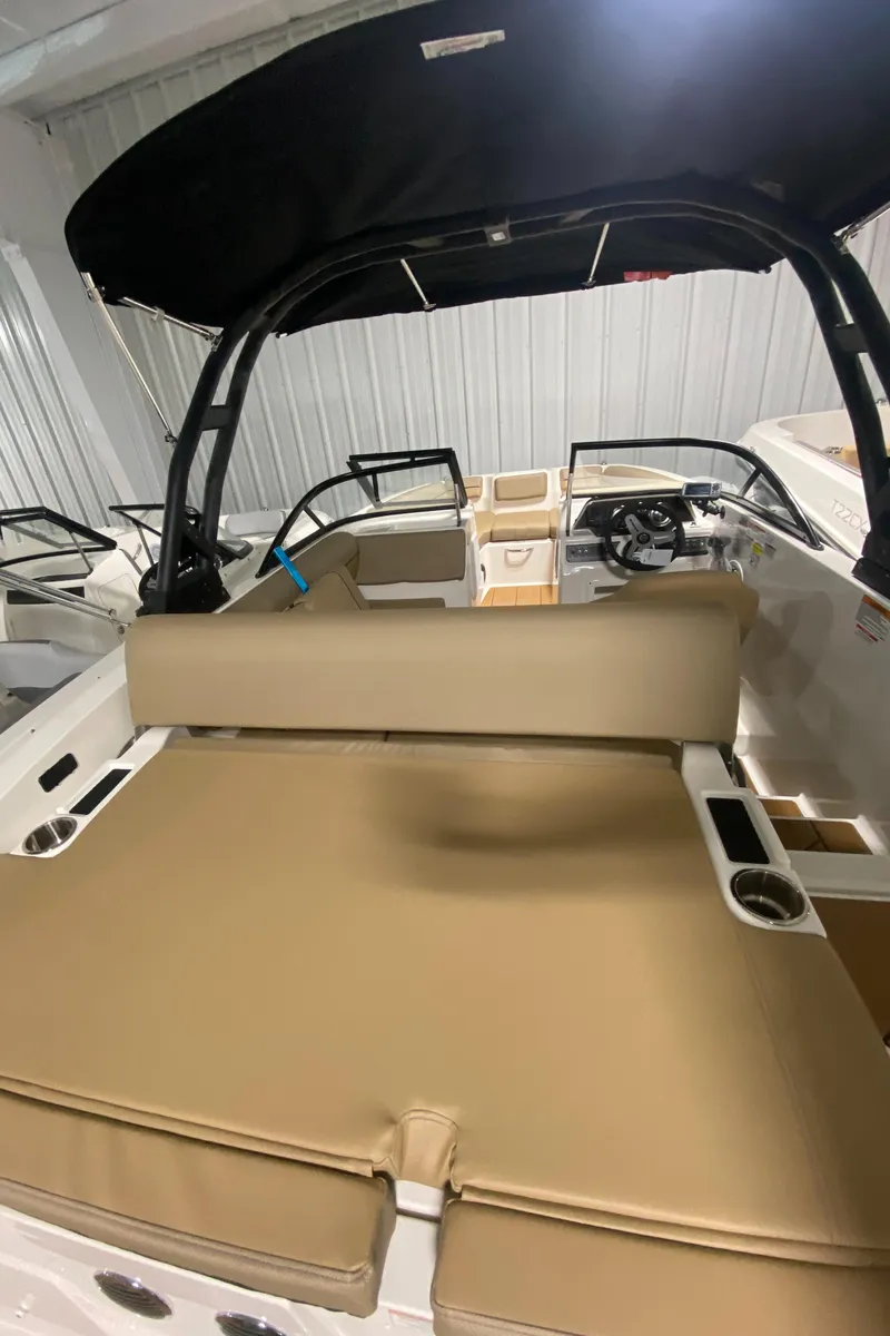 Slide: The Image of 2024 Bayliner DX2000 boat interior with tan seating and black canopy. - 25