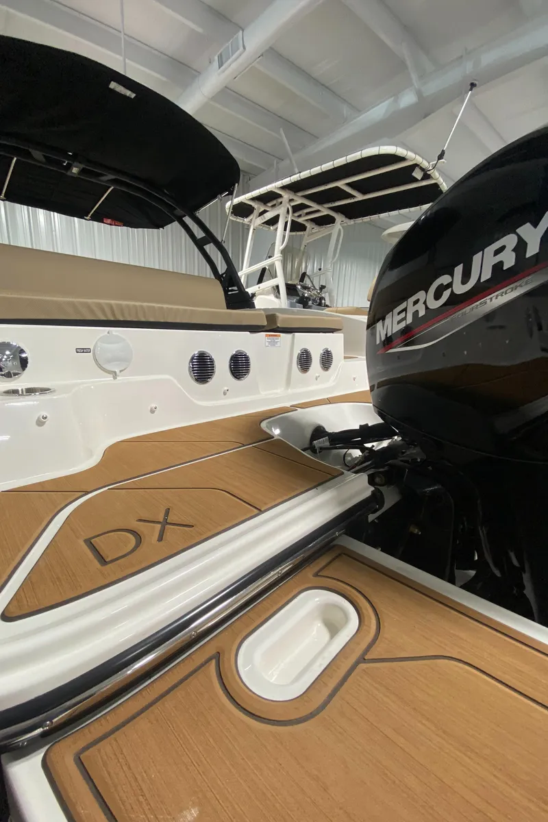 Slide: The Image of 2024 Bayliner DX2000 boat with Mercury engine, teak deck, and modern interior. - 26