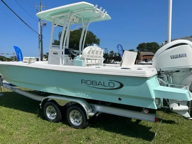 Slide: The Image of 2024 Robalo 246 Cayman boat on a trailer, side view, outdoors. - 1
