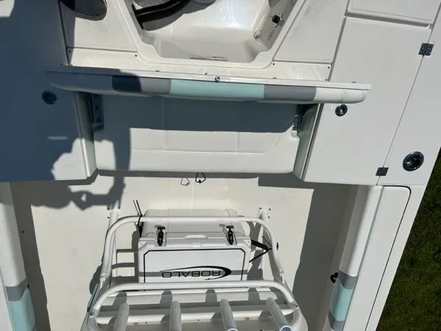 Slide: The Image of 2024 Robalo 246 Cayman boat interior, featuring storage compartments and rod holders. - 6