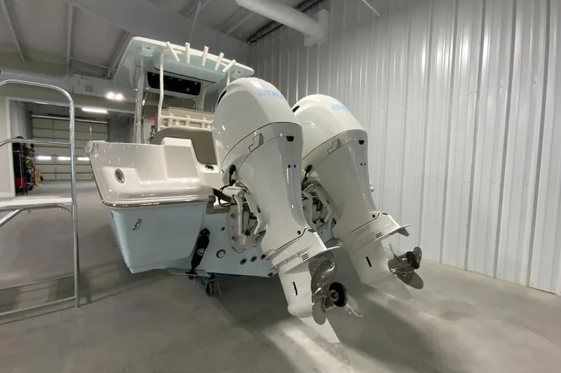 Slide: The Image of 2024 Key West 263 FS boat with twin outboard engines in a storage facility. - 2