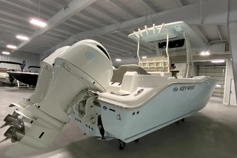 Slide: The Image of 2024 Key West 263 FS boat in showroom, rear view with dual outboard engines. - 7