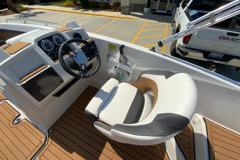 Slide: The Image of 2024 Starcraft SVX 191 boat cockpit with steering wheel and captain's chair. - 23