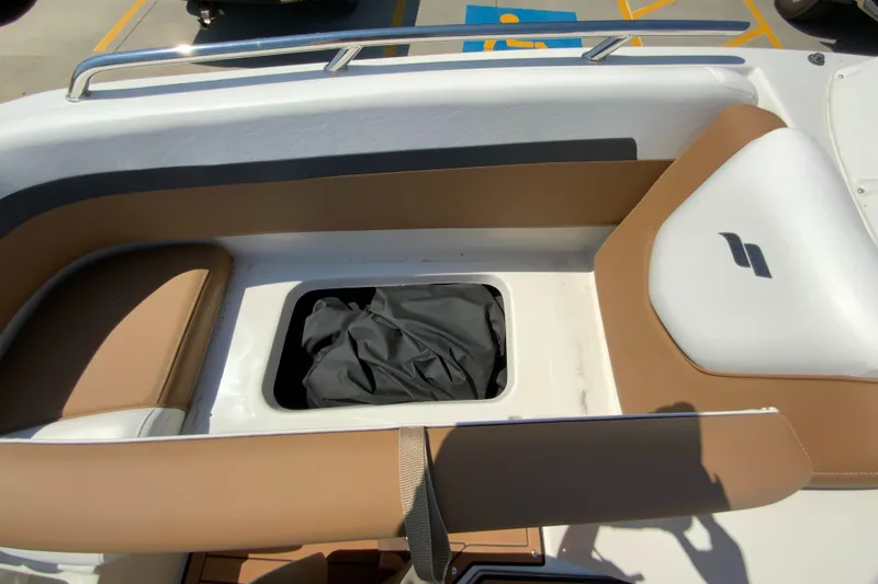 Slide: The Image of 2023 Starcraft SVX 211 boat interior with storage compartment and tan seating. - 18