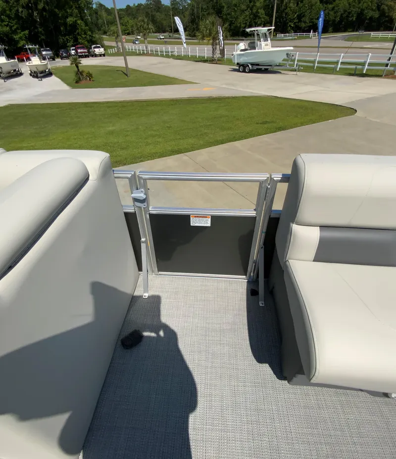 Slide: The Image of 2024 Starcraft LX20 R pontoon boat interior with beige seating and gate. - 14