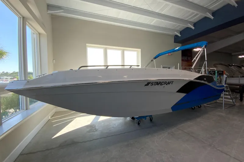 Slide: The Image of 2024 Starcraft SVX 231 boat displayed indoors with blue accents. - 2