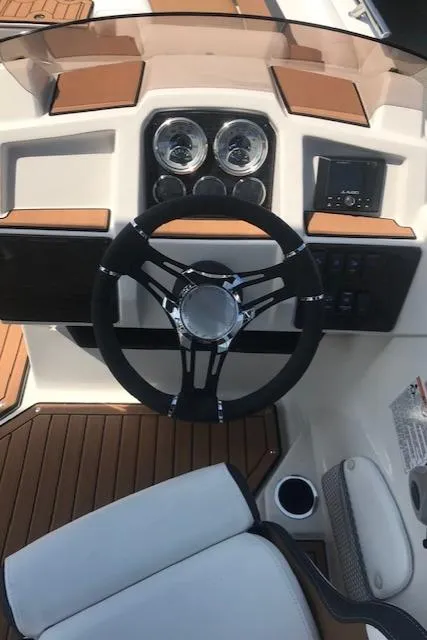 Slide: The Image of 2024 Starcraft SVX 211 boat dashboard with steering wheel and gauges. - 6