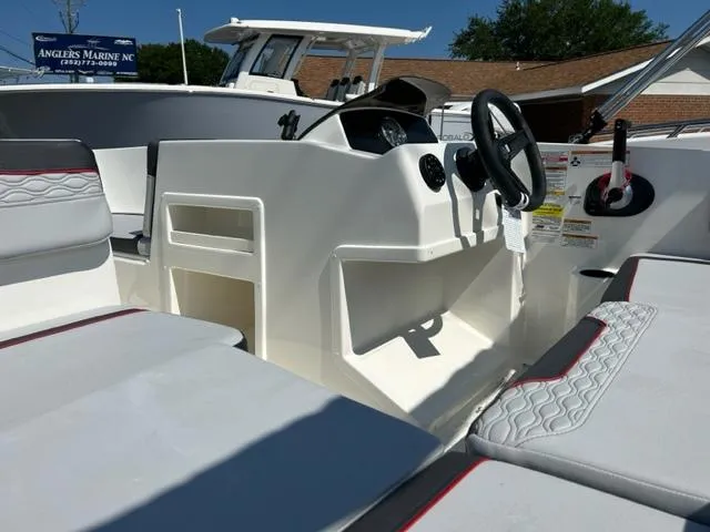 Slide: The Image of 2024 Bayliner Element M17 boat interior with steering console and seating. - 13