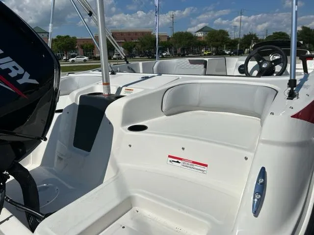 Slide: The Image of 2024 Bayliner Element M17 boat interior with Mercury engine, white seating, and steering wheel. - 8