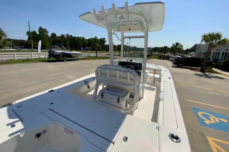 Slide: The Image of 2024 Robalo 246 Cayman boat with T-top and seating, parked on a sunny day. - 6